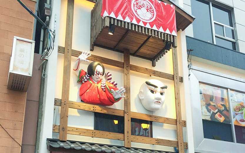 Dotonbori Museum Namikiza entrance with traditional Japanese masks and red lanterns.