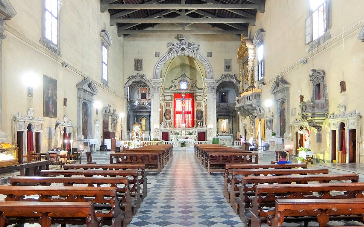 Brancacci Chapel interior with ornate altar and wooden pews, Florence, Italy.