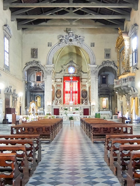 Brancacci Chapel interior with ornate altar and wooden pews, Florence, Italy.