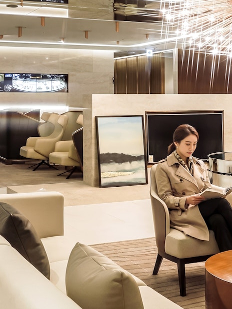 Traveler reading in Matina Gold lounge, Terminal 2, Incheon International Airport.