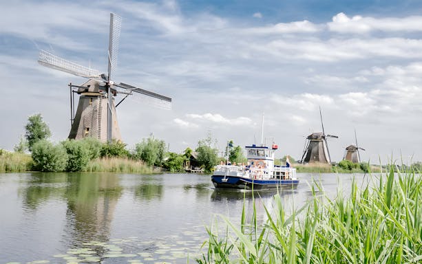 Boat tour passing windmills at Kinderdijk, Netherlands, on a UNESCO World Heritage small group half-day trip.