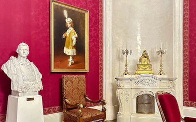 Bust, painting, and ornate decor in Royal Palace of Gödöllő, Hungary interior.