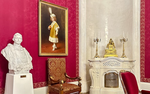 Bust, painting, and ornate decor in Royal Palace of Gödöllő, Hungary interior.