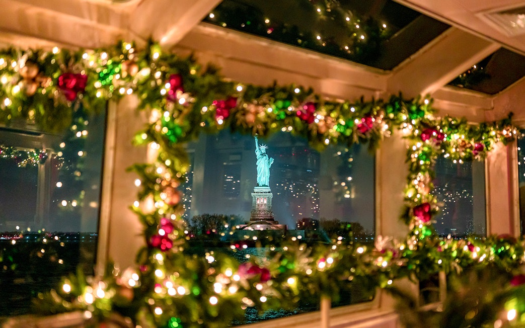 Statue of Liberty viewed through decorated cruise window at night.