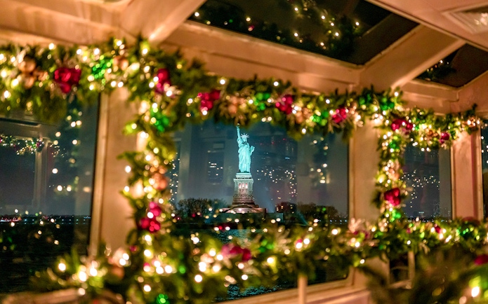 Statue of Liberty viewed through decorated cruise window at night.