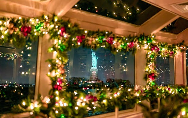 Statue of Liberty viewed through decorated cruise window at night.
