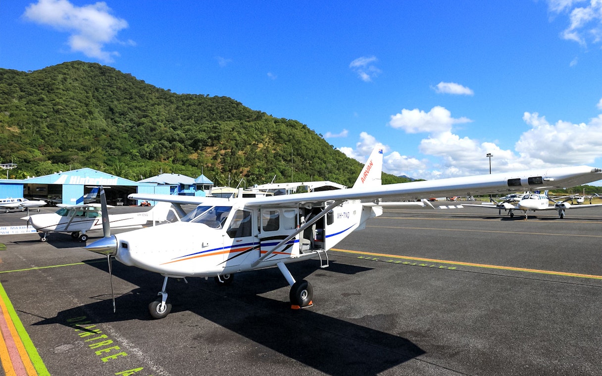 Plane on Cairns airport tarmac before scenic flight to Great Barrier Reef.