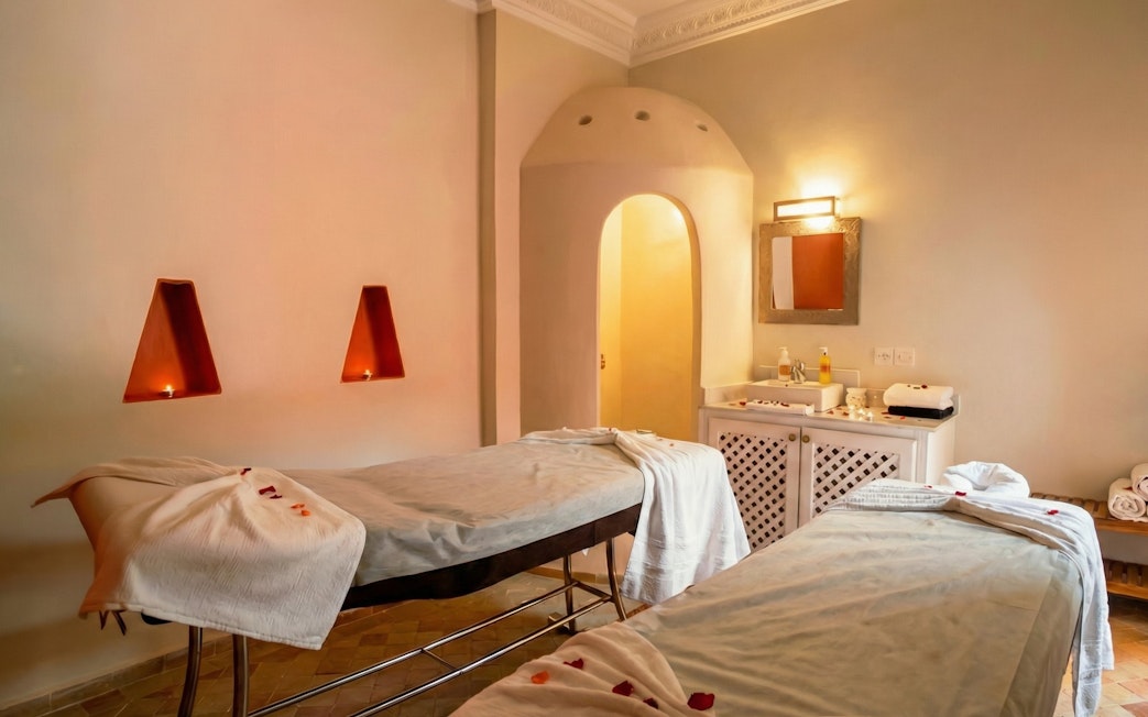 Spa therapy room with massage tables and candles at Moroccan Hammam, Marrakech.