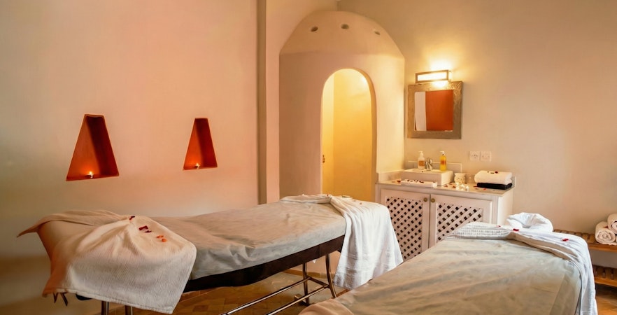 Spa therapy room with massage tables and candles at Moroccan Hammam, Marrakech.