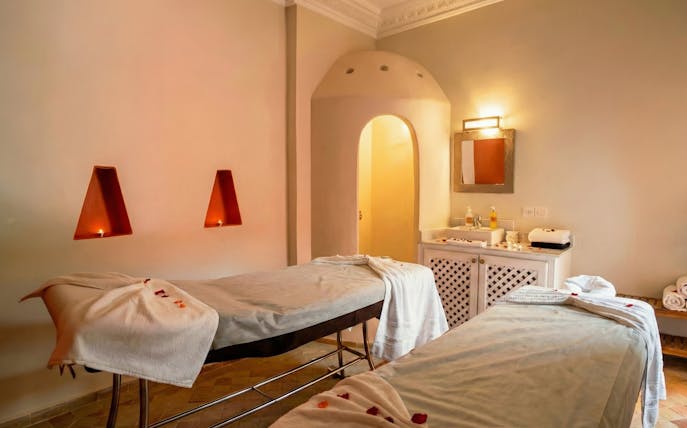 Spa therapy room with massage tables and candles at Moroccan Hammam, Marrakech.