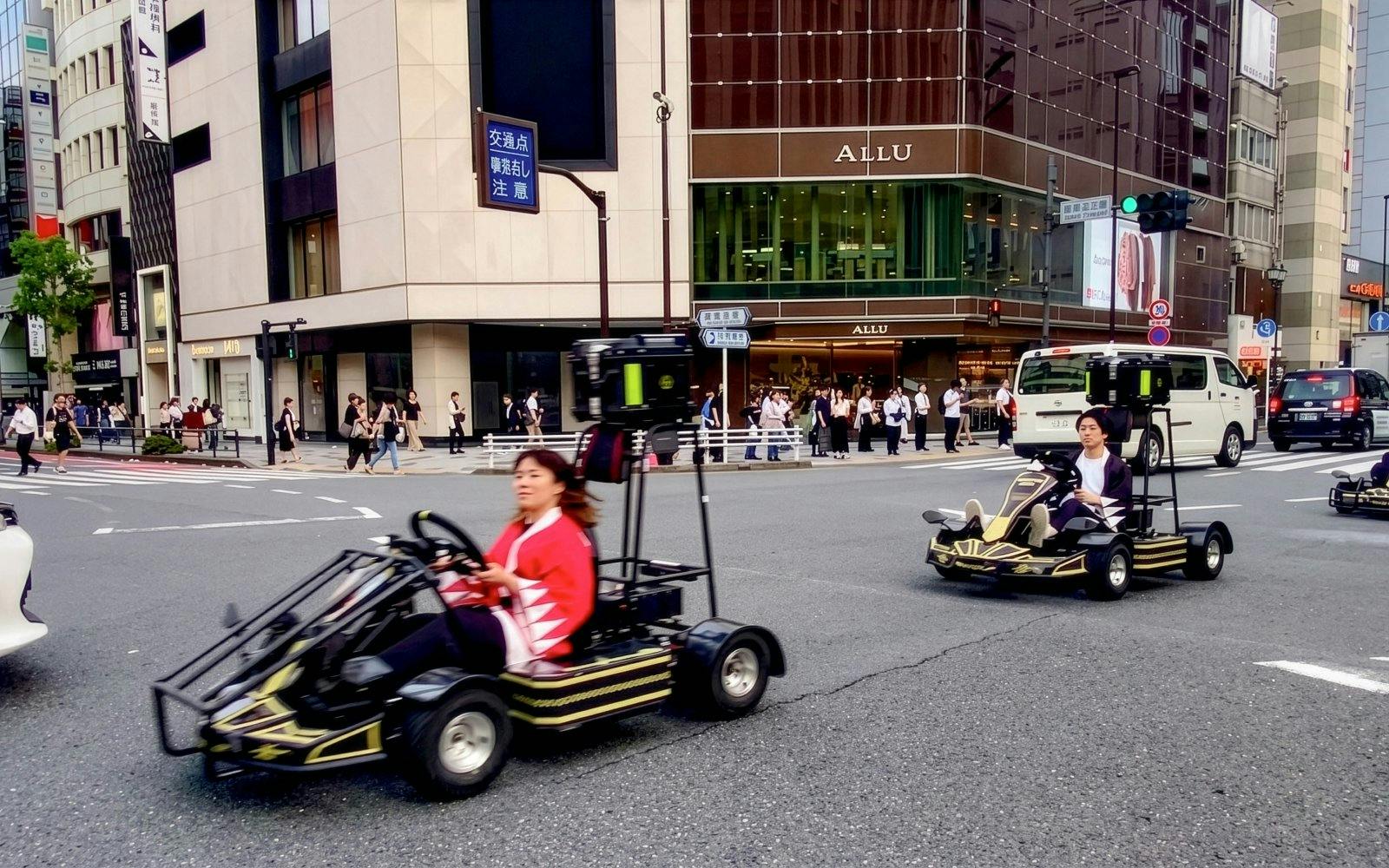 Street karts driving through a busy intersection in Tokyo.