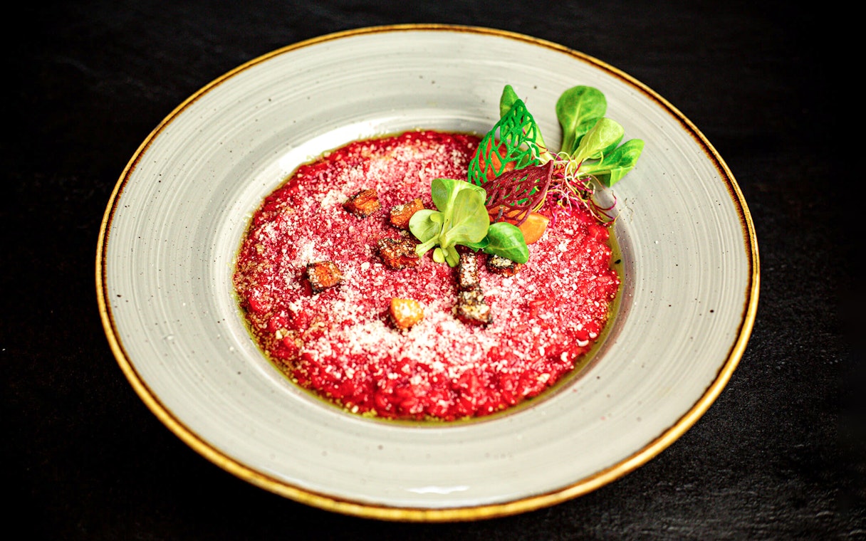 Beetroot risotto garnished with greens on Budapest New Year’s Eve cruise.