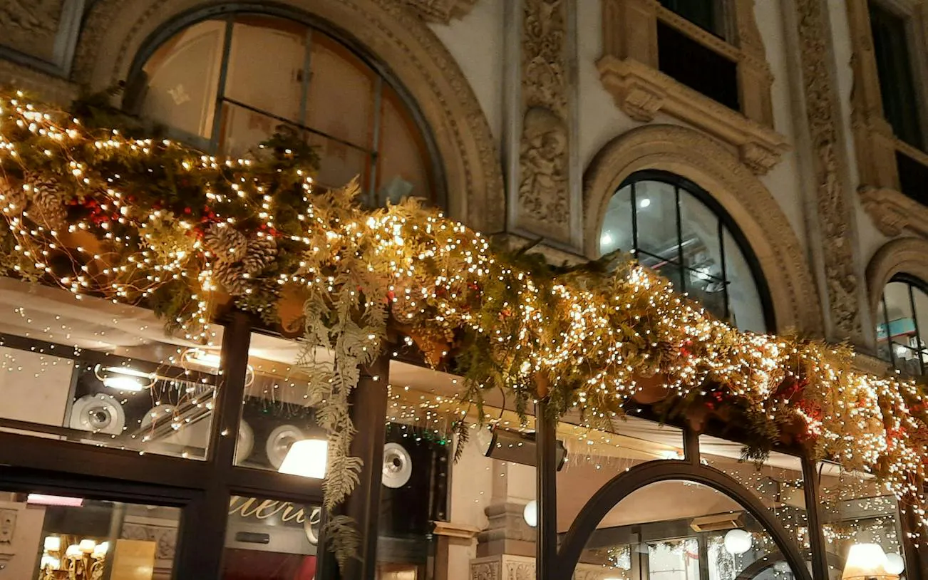 Christmas lights and decorations on a historic building in Milan during a self-guided city exploration game.