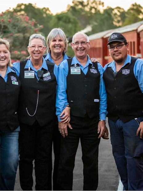 Mary Valley Rattler train crew standing beside a red train at Gympie station.