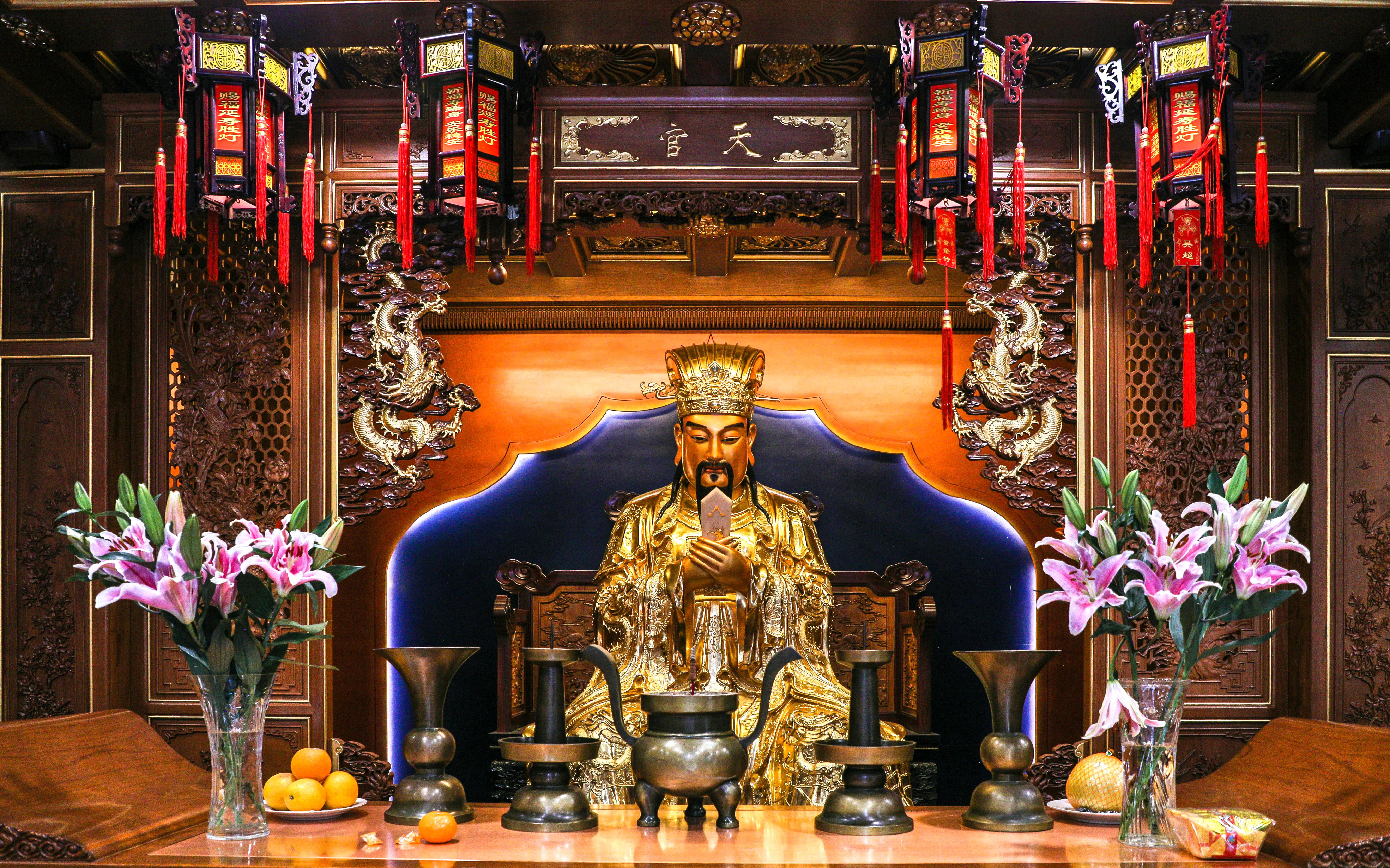 Shanghai City God Temple altar with deity statue, ornate carvings, lanterns, and offerings.