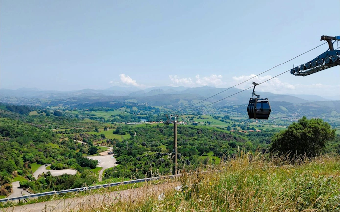 Cable car over lush landscape at Cabárceno Nature Park, Spain.