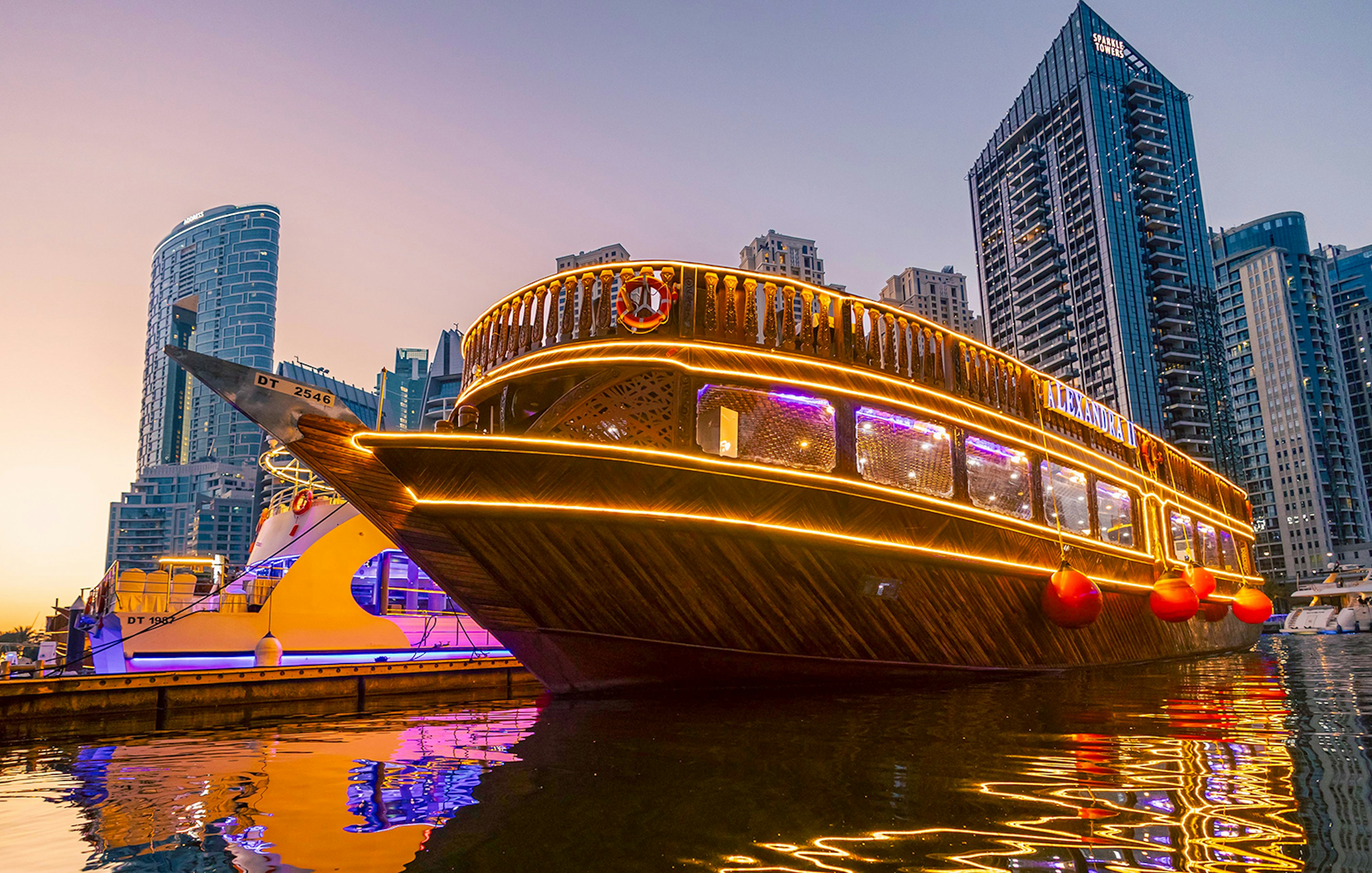 Alexandra Dhow Cruise with lights at Dubai Marina during sunset.