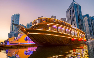 Alexandra Dhow Cruise with lights at Dubai Marina during sunset.
