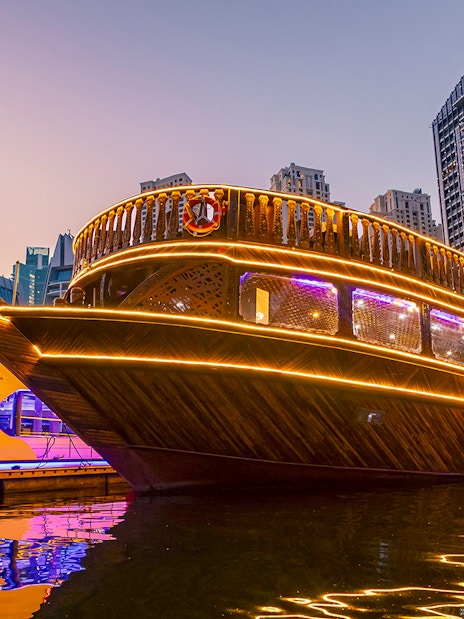 Alexandra Dhow Cruise with lights at Dubai Marina during sunset.