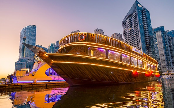 Alexandra Dhow Cruise with lights at Dubai Marina during sunset.