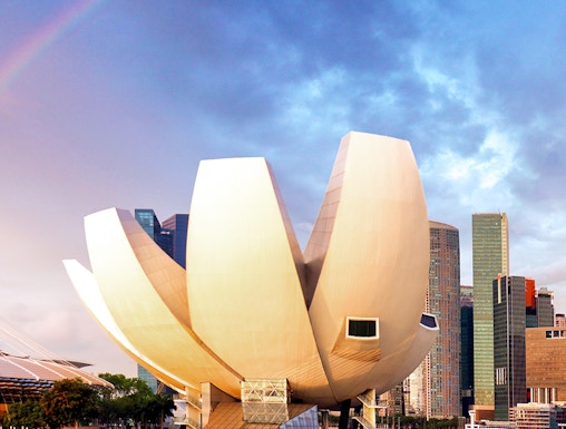 ArtScience Museum in Singapore with city skyline and rainbow in the background.