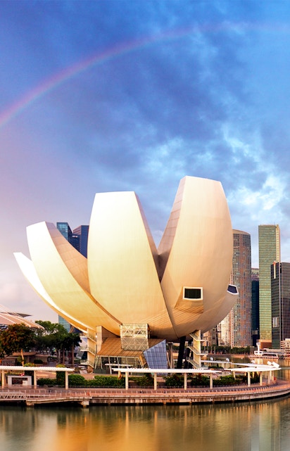 ArtScience Museum in Singapore with city skyline and rainbow in the background.