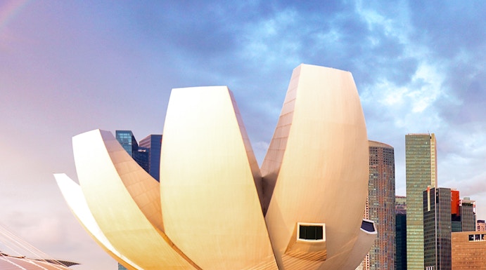 ArtScience Museum in Singapore with city skyline and rainbow in the background.