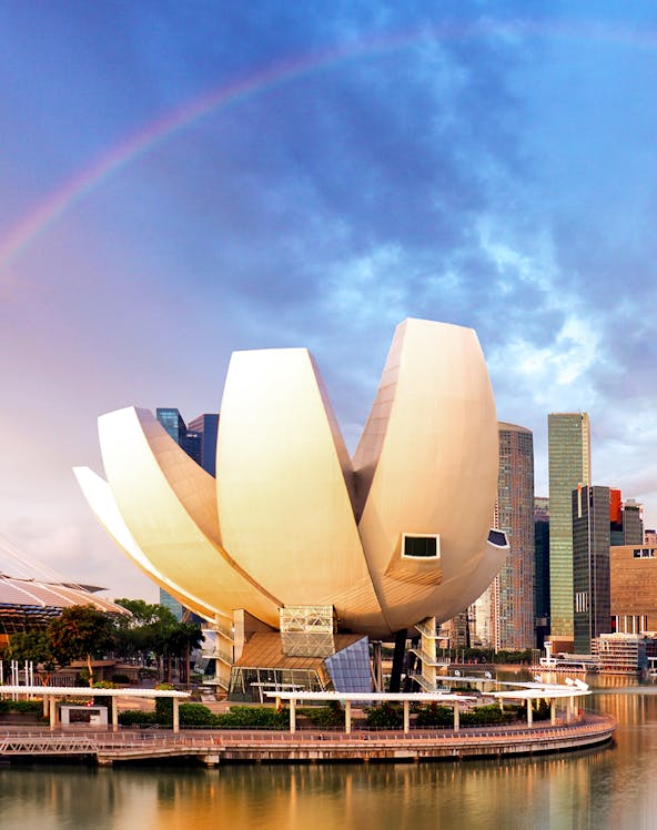 ArtScience Museum in Singapore with city skyline and rainbow in the background.