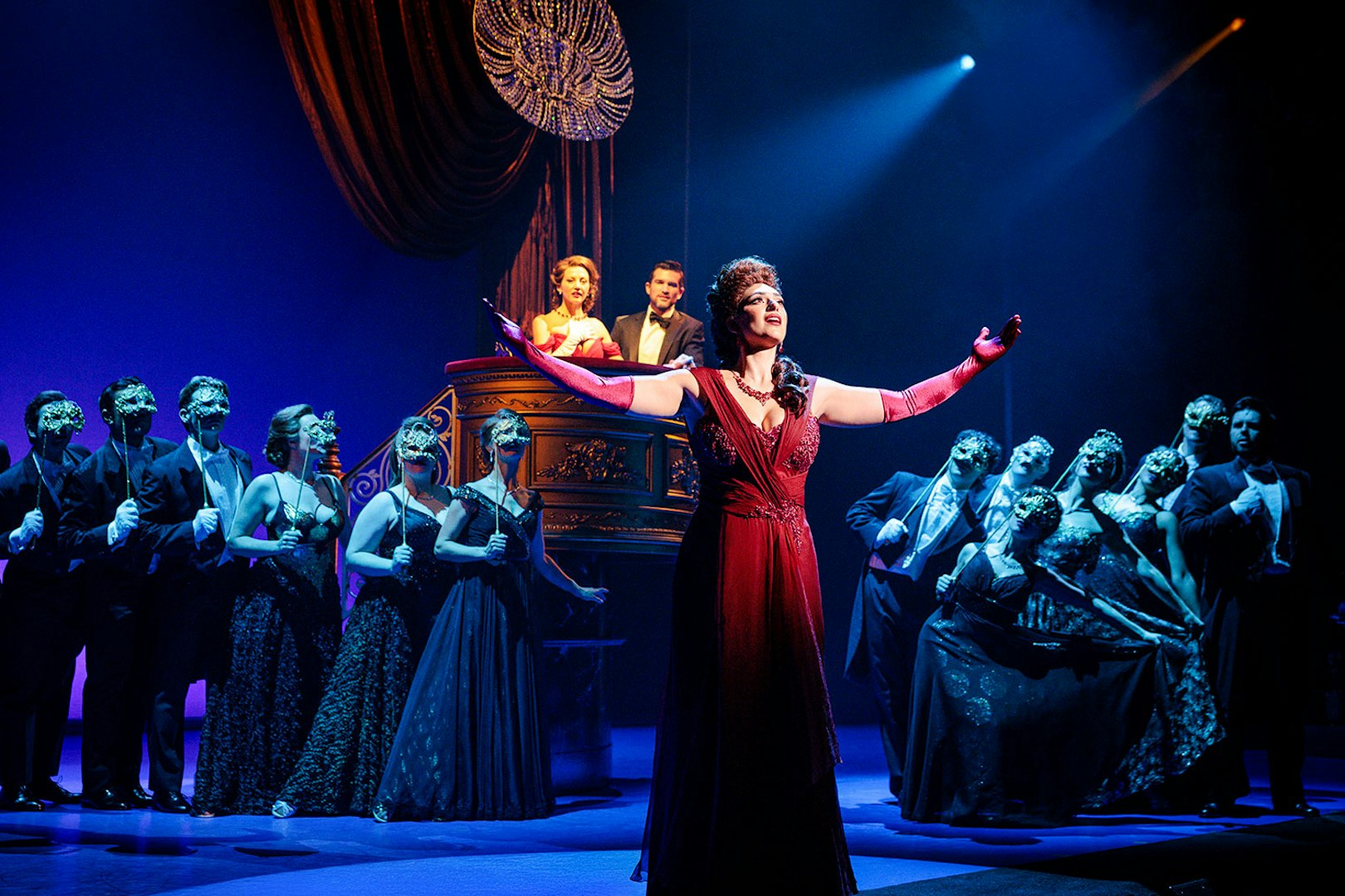 Cast performing a scene from Pretty Woman The Musical with vibrant stage lighting.