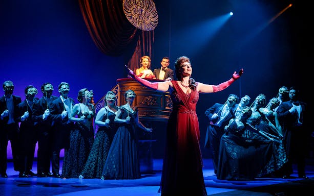 Cast performing a scene from Pretty Woman The Musical with vibrant stage lighting.