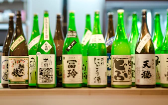 Bottles of sake displayed on a bar shelf in Japan.