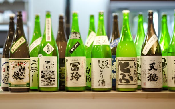 Bottles of sake displayed on a bar shelf in Japan.