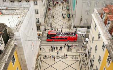 Lisbon hop-on hop-off bus on a patterned street near São Jorge Castle.