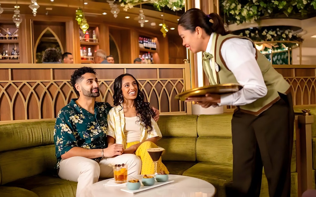 Couple enjoying drinks at Tianas Bayou Lounge on Disney Adventure Cruise.