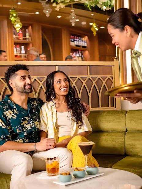 Couple enjoying drinks at Tianas Bayou Lounge on Disney Adventure Cruise.