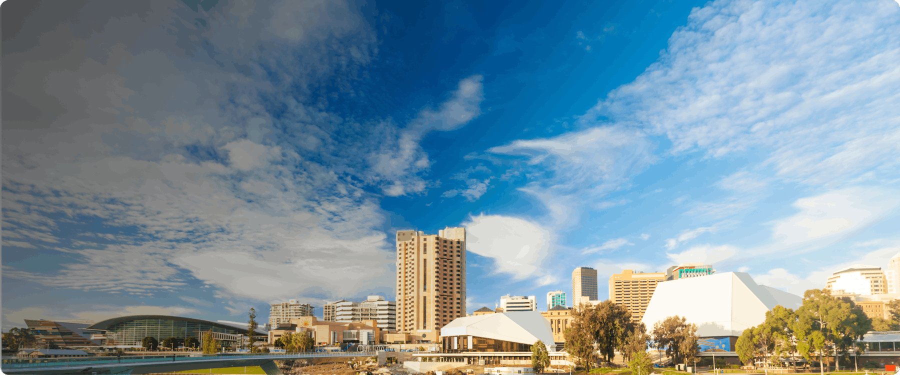 Adelaide city skyline with modern buildings and blue sky.