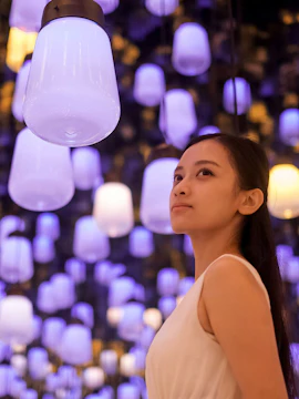 Person admiring glowing lanterns at teamLab Biovortex, Kyoto Walking Tour.