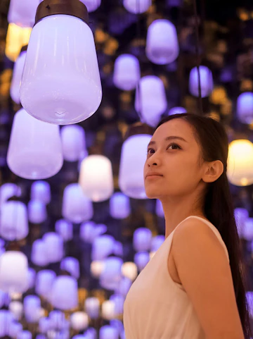 Person admiring glowing lanterns at teamLab Biovortex, Kyoto Walking Tour.