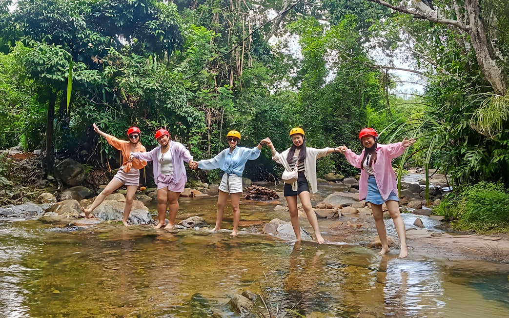Group enjoying Langkawi Sky ATV Ride at Mountain Manchinchang, standing in a forest stream.