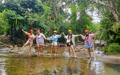 Group enjoying Langkawi Sky ATV Ride at Mountain Manchinchang, standing in a forest stream.