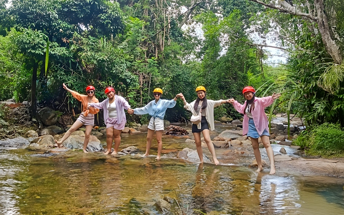 Group enjoying Langkawi Sky ATV Ride at Mountain Manchinchang, standing in a forest stream.