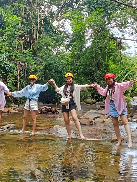 Group enjoying Langkawi Sky ATV Ride at Mountain Manchinchang, standing in a forest stream.