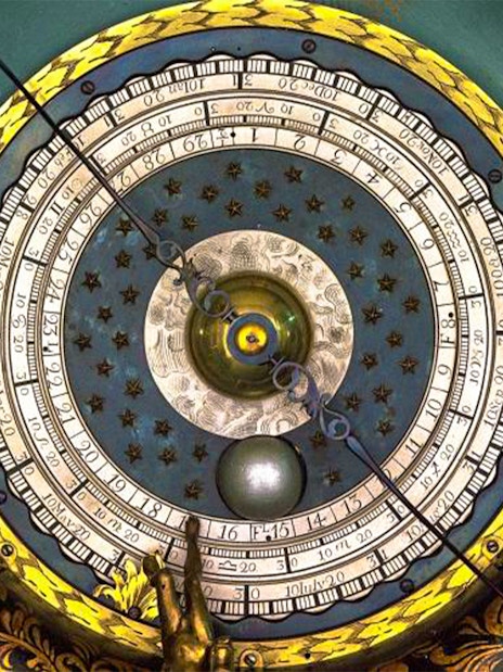 Astronomical clock face at Royal Observatory Greenwich, featuring intricate dials and celestial motifs.
