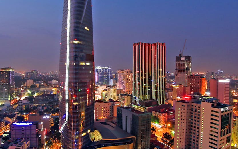 Saigon Skydeck nightscape view of Ho Chi Minh City skyline with illuminated skyscrapers and bustling streets.