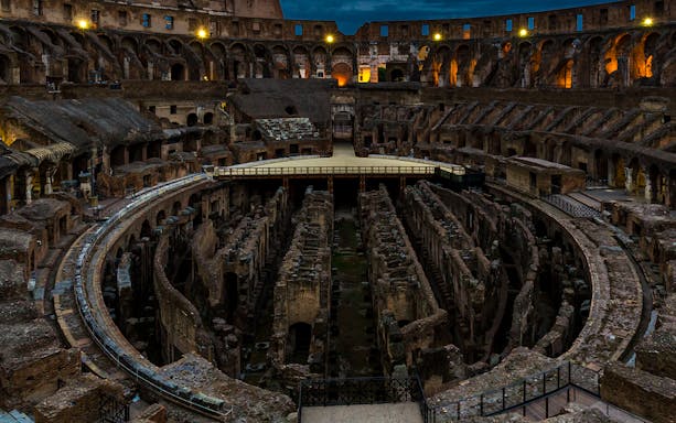 Colosseum Hypogeum illuminated at night, showcasing ancient underground structures in Rome.