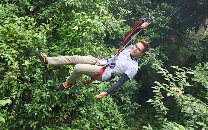 Person ziplining through lush forest at Skytrex Adventure Langkawi.