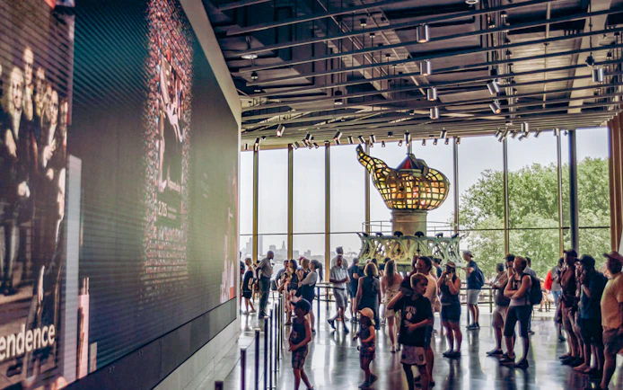 Visitors inside the Statue of Liberty Museum viewing the original torch exhibit.