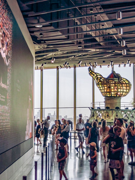 Visitors inside the Statue of Liberty Museum viewing the original torch exhibit.
