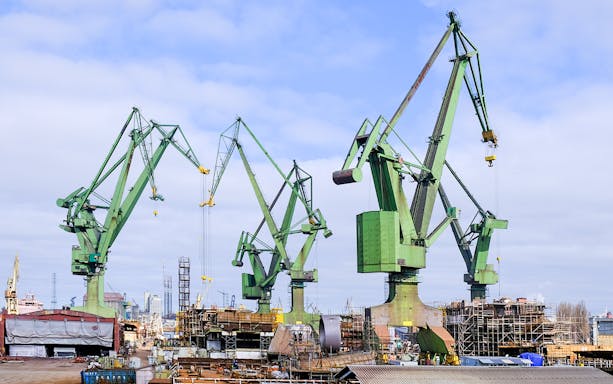 Cranes at Gdansk Shipyard in Poland against a cloudy sky.