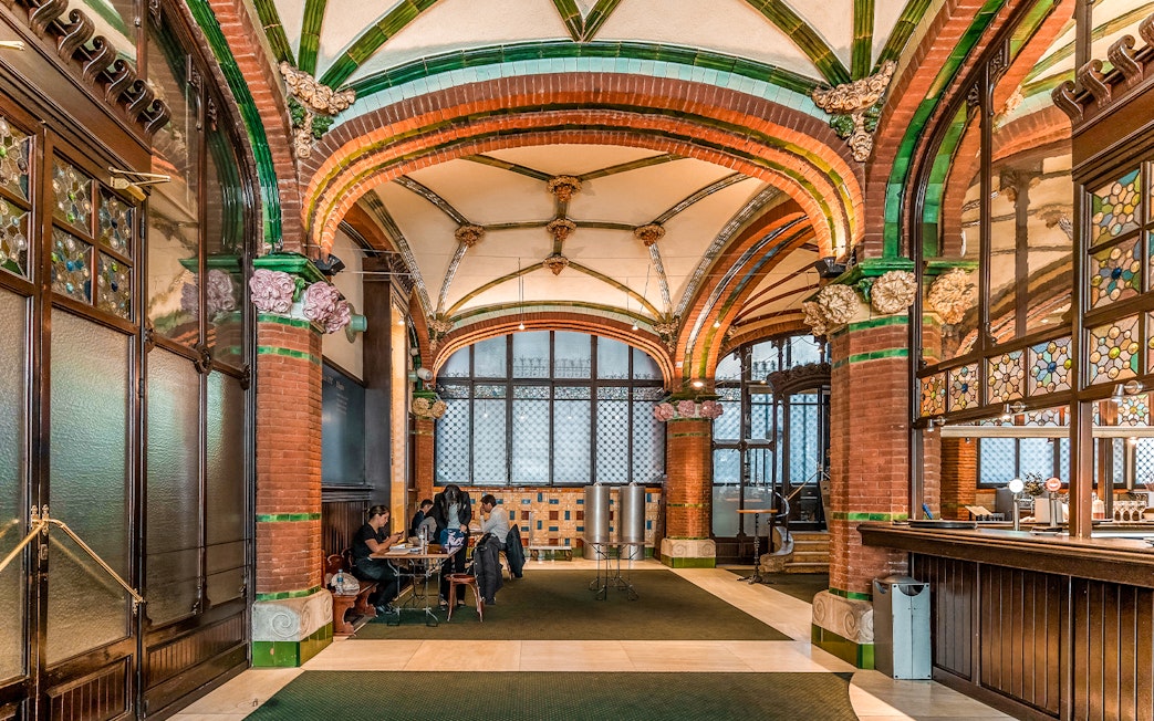 Hall inside Palau de la Musica Catalana with stained glass and ornate arches.